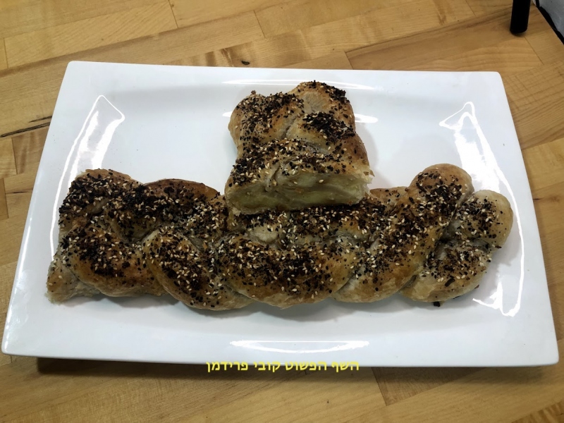 חלה לשבת בצק עלים ממולאת בפירה תפוא זיתים ובצל מקורמל בציפוי תערובת תיבול לביגל אמריקאי צמחוני