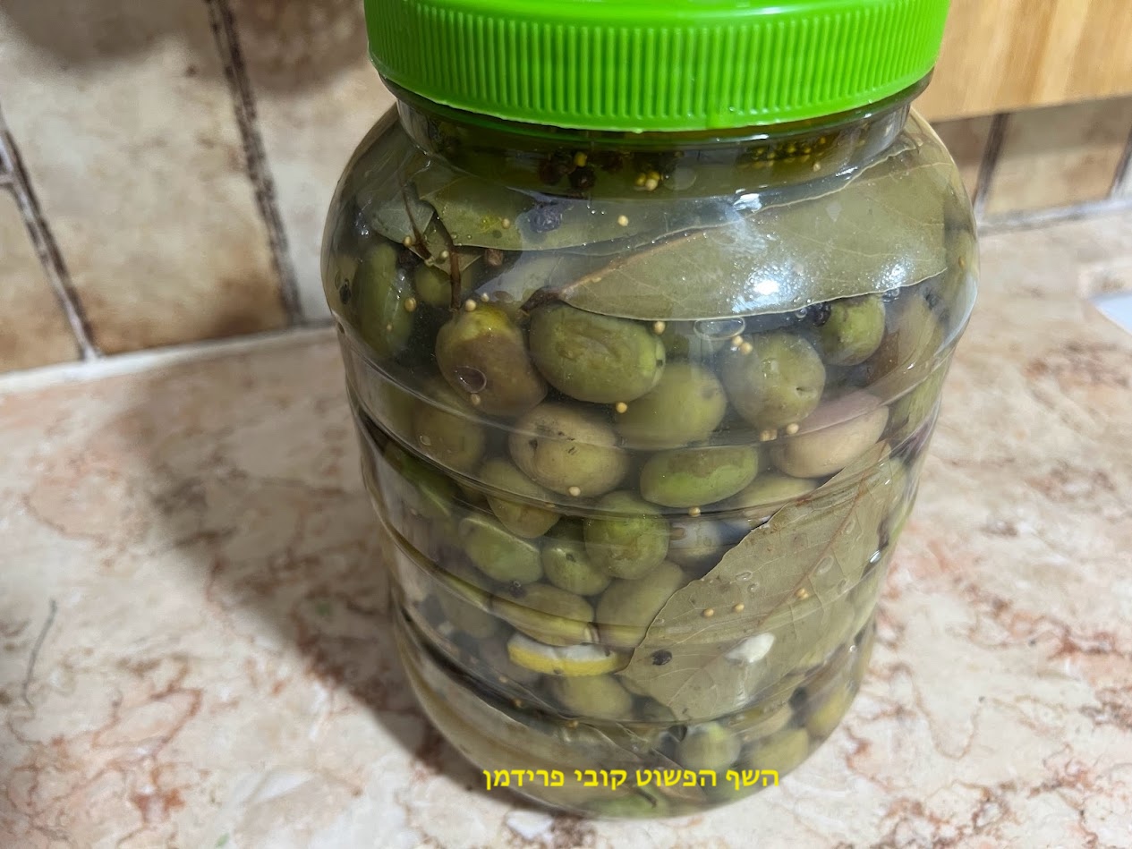 זיתים דפוקים מובחרים עם פלפל שחור זרעי חרדל שום לימון ועלי דפנה 